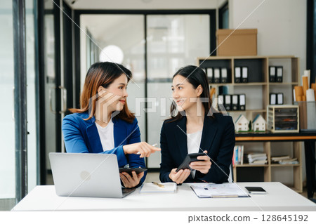 Businesswoman leading team meeting and using tablet and laptop computer with financial in office 128645192