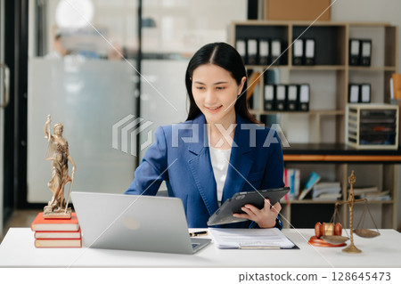 justice and law concept. asian woman lawyer working and judge in a courtroom the gavel, working with tablet and laptop justice and law concept. asian woman lawyer working and judge in a courtroom the gavel, working with tablet and laptop 128645473