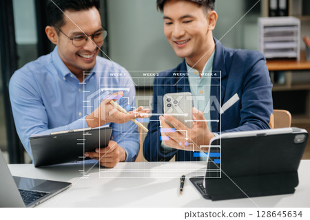 Project manager working and update tasks with milestones progress planning and Gantt chart scheduling diagram. business working with smart phone, tablet and laptop in office. Project manager working and update tasks with milestones progress planning and Gantt chart scheduling diagram. business working with smart phone, tablet and laptop in office. 128645634