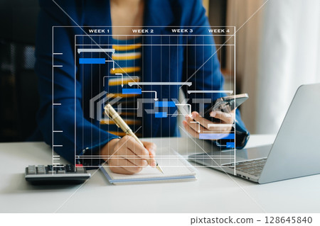 Project manager working and update tasks with milestones progress planning and Gantt chart scheduling diagram. business working with smart phone, tablet and laptop in office. Project manager working and update tasks with milestones progress planning and Gantt chart scheduling diagram. business working with smart phone, tablet and laptop in office. 128645840