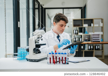 Male scientist researcher conducting an experiment in a laboratory. 128646402