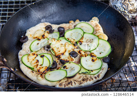 Baking homemade pizza on an outdoor barbecue 128646514