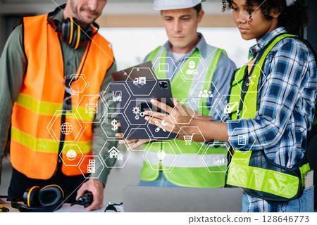 Two colleagues discussing data working and tablet, laptop with on on architectural project at construction site at desk in office Two colleagues discussing data working and tablet, laptop with on on architectural project at construction site at desk in office 128646773