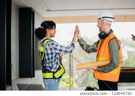 Construction team shake hands greeting start new project plan behind yellow helmet in office center to consults about their building project. Construction team shake hands greeting start new project plan behind yellow helmet in office center to consults about their building project. 128646792