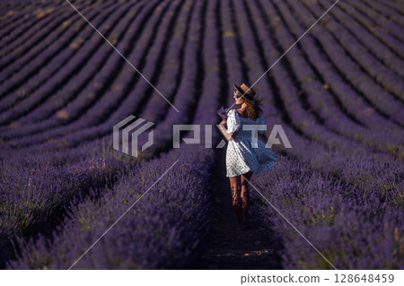 Lavender Woman Fields: Tourist walking through purple lavender fields in Provence, France, during summer. 128648459