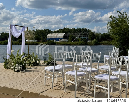 White chairs for the guests of the wedding ceremony are on the site. High quality photo 128648838