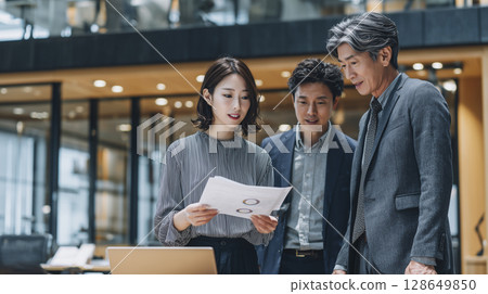 A scene of multiple business people having a meeting in an open office A scene of multiple business people having a meeting in an open office 128649850