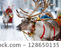 Reindeer adorned with colorful decorations stands in snowy landscape, with festive sleigh and Santa figure in the background, capturing the essence of holiday spirit and winter wonder 128650135