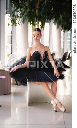 Ballerina in black tutu sitting gracefully with eyes closed 128650608