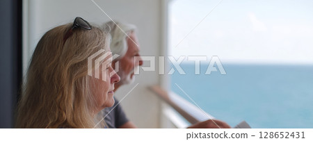 Senior Couple Enjoying Leisure Time Together by the Ocean on a Comfortable Balcony Setting 128652431
