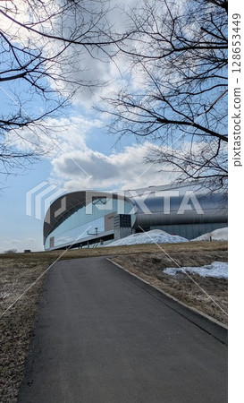 Daiwa House Premist Dome shining on the ground, blue sky, clouds and trees Daiwa House Premist Dome shining on the ground, blue sky, clouds and trees 128653449