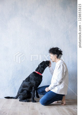 Man playing with a large dog Man playing with a large dog 128653815