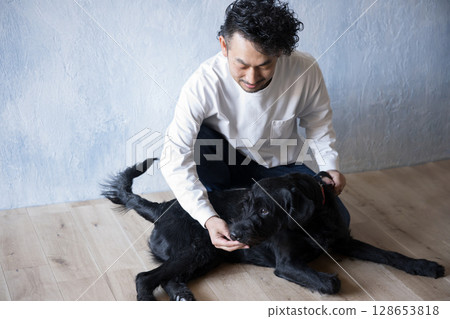 Man playing with a large dog 128653818