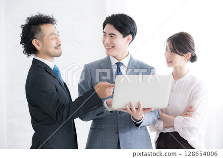 Businessmen pointing at a computer working as a team Businessmen pointing at a computer working as a team 128654006