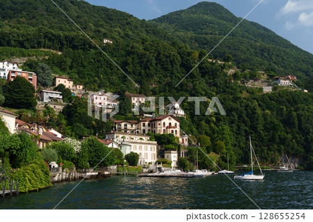 Villas on the shores of Lake Como, Italy - Summer landscape with hills and architecture. Villas on the shores of Lake Como, Italy - Summer landscape with hills and architecture. 128655254