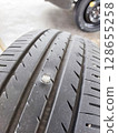 screw puncturing car tire. macro closeup. 128655258
