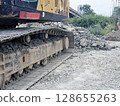 Metal excavator track background. Construction site ground. Heavy machinery equipment. 128655263