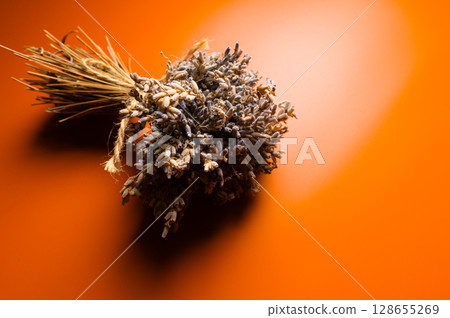 Top view of collected and dried lavender bouquet on orange background. Space for text Top view of collected and dried lavender bouquet on orange background. Space for text 128655269