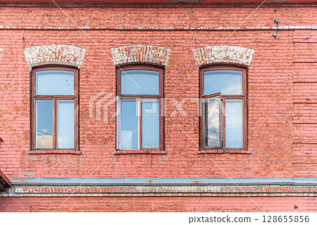 Three windows of the old mansion 19 century with brown bricks wall 128655856