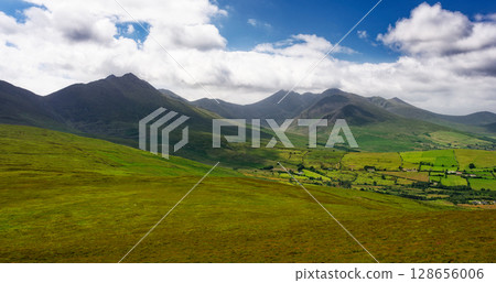 Gentle slopes of vibrant green lead the eye to towering peaks, a testament to nature's power and beauty. Gentle slopes of vibrant green lead the eye to towering peaks, a testament to nature's power and beauty. 128656006