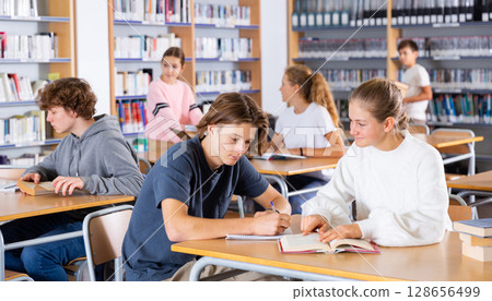 Schoolchildren write out a synopsis from the textbook 128656499