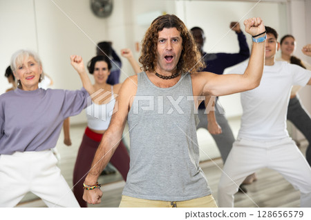 Emotional man practicing hip-hop movements during group class 128656579