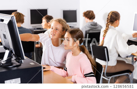 Portrait of female and male students working on computers in class room 128656581