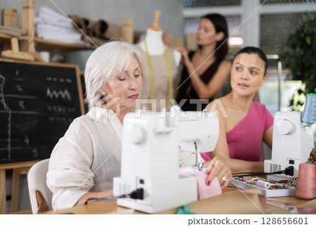 Mature and middle-aged women working with sewing machine Mature and middle-aged women working with sewing machine 128656601