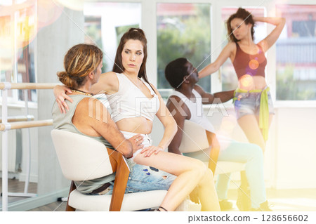 Female dancer mastering lap dance with man sitting on chair in studio 128656602