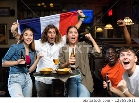 Group of France football team fans spending time in bar 128656611