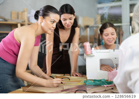 Woman practicing pattern drafting during sewing course Woman practicing pattern drafting during sewing course 128656619
