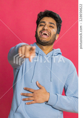 Happy excited Indian man laughing out loud after hearing ridiculous anecdote, reaction on funny joke Happy excited Indian man laughing out loud after hearing ridiculous anecdote, reaction on funny joke 128656622