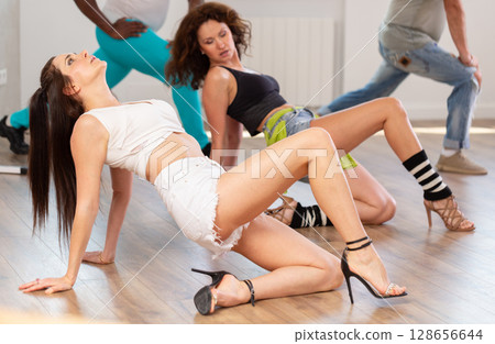 Women in heels dancing on floor in studio Women in heels dancing on floor in studio 128656644