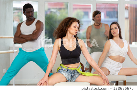 Women in heels dance while sitting on chair 128656673