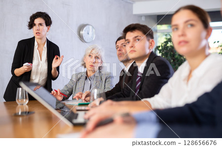 Latin American woman presenting business strategy to partners in office 128656676