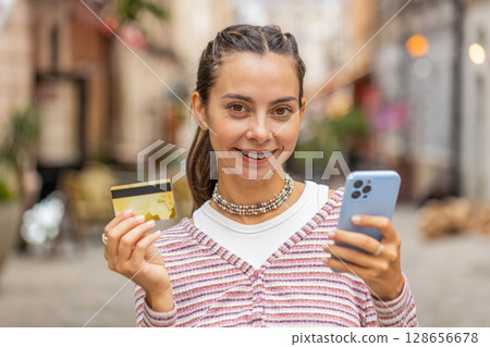 Woman using credit bank card smartphone while transferring money, purchases online shopping, order Woman using credit bank card smartphone while transferring money, purchases online shopping, order 128656678