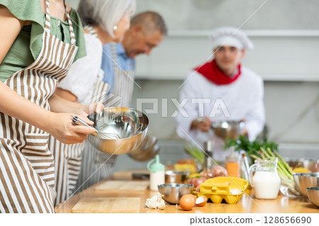 Metal bowl with sauce mixed by young woman's hands 128656690