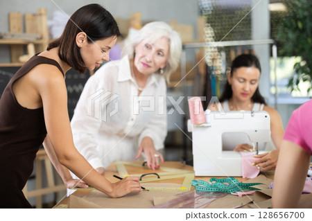 Adult woman teacher explains to group how to draw pattern 128656700