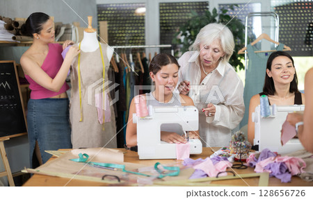 Group of women sew and work with mannequin at master class Group of women sew and work with mannequin at master class 128656726