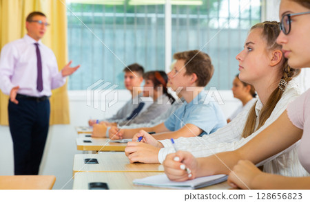 Students listening task for exam in classroom Students listening task for exam in classroom 128656823