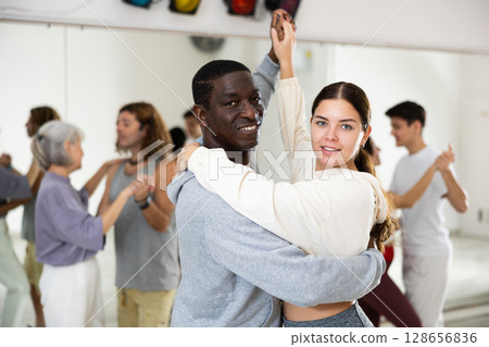 Positive couple of dancers learns a slow foxtrot 128656836