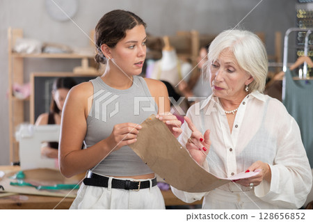 Sewing teacher reviewing pattern with student during class 128656852