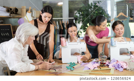 Adult woman teacher explains to group how to draw pattern 128656924