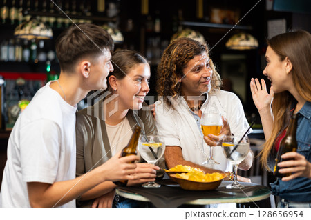 Group of happy carefree people spending time in pub Group of happy carefree people spending time in pub 128656954