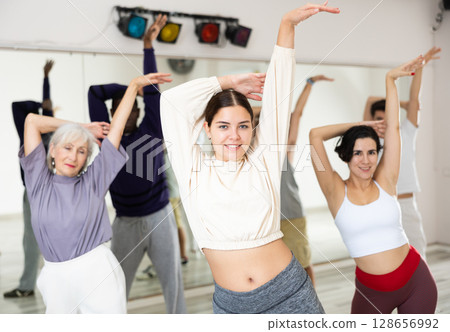 Young girl enjoying practicing passionate bachata during group class 128656992