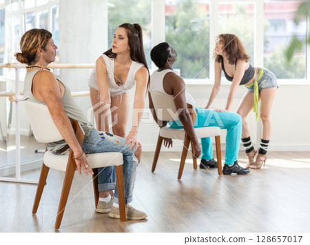 Woman dancing for man sitting on chair 128657017