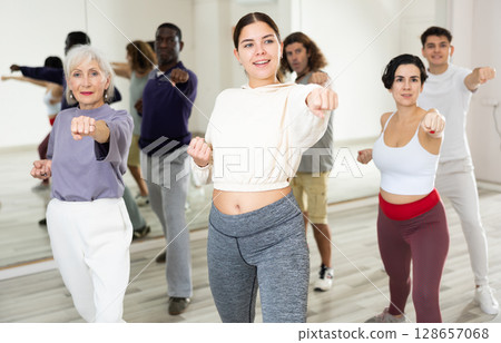 Girl practicing punches during group self defense course Girl practicing punches during group self defense course 128657068