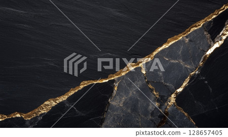 Cracked black slate stones with golden veins 128657405