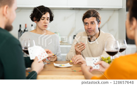 Two married couples playing card game poker 128657648