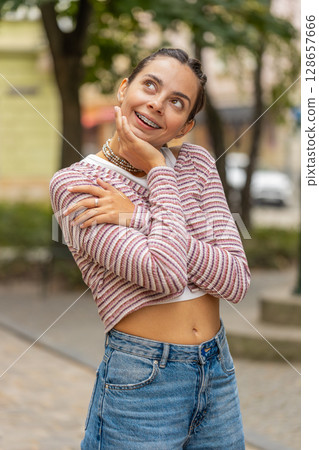 Thoughtful smiling happy young woman with pensive expression pondering a solution dreaming thinking Thoughtful smiling happy young woman with pensive expression pondering a solution dreaming thinking 128657666